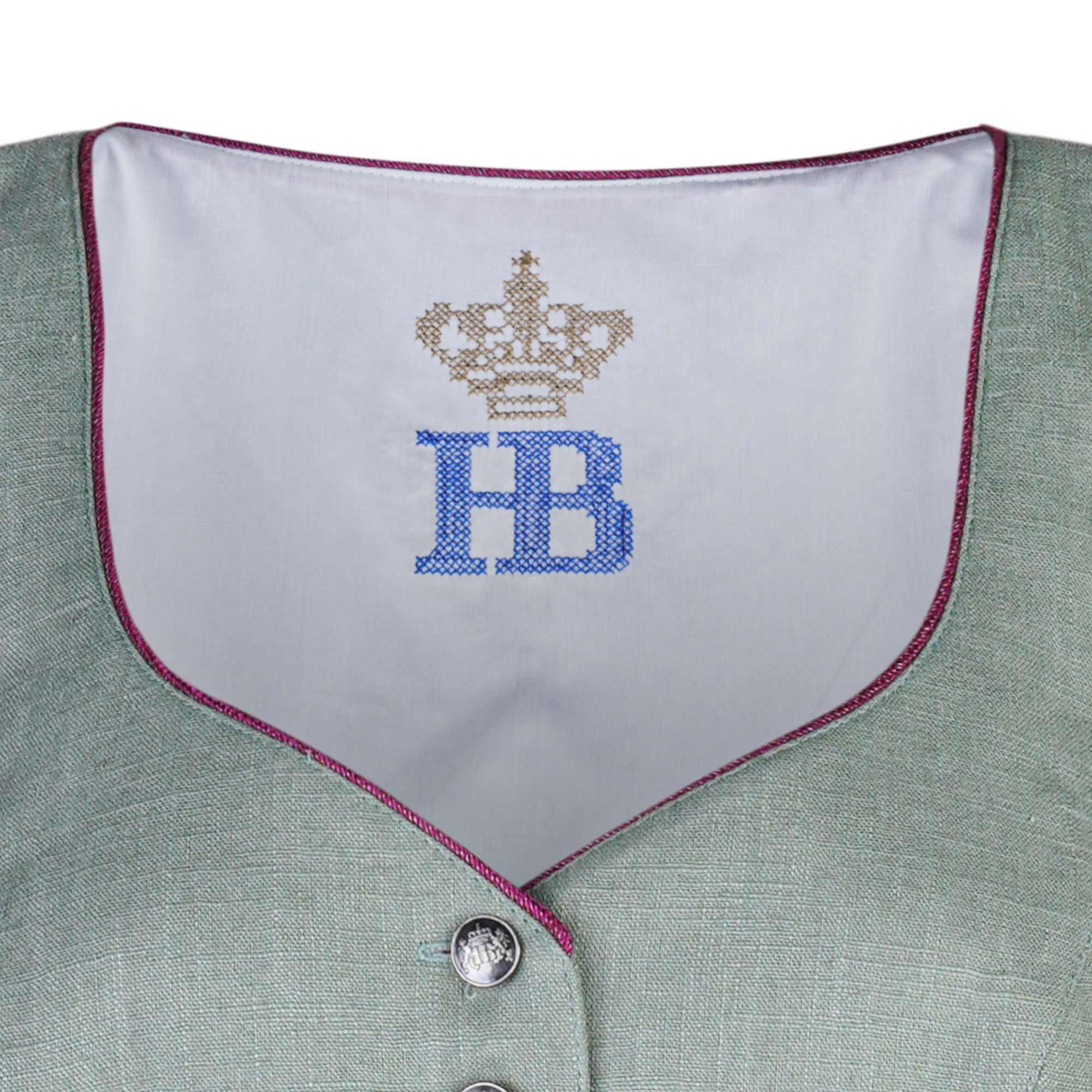 Nahaufnahme des Dirndlausschnitts mit weißem Innenfutter, goldenem Kronenlogo und blauer "HB"-Stickerei, eingefasst mit einer feinen pinken Paspel.