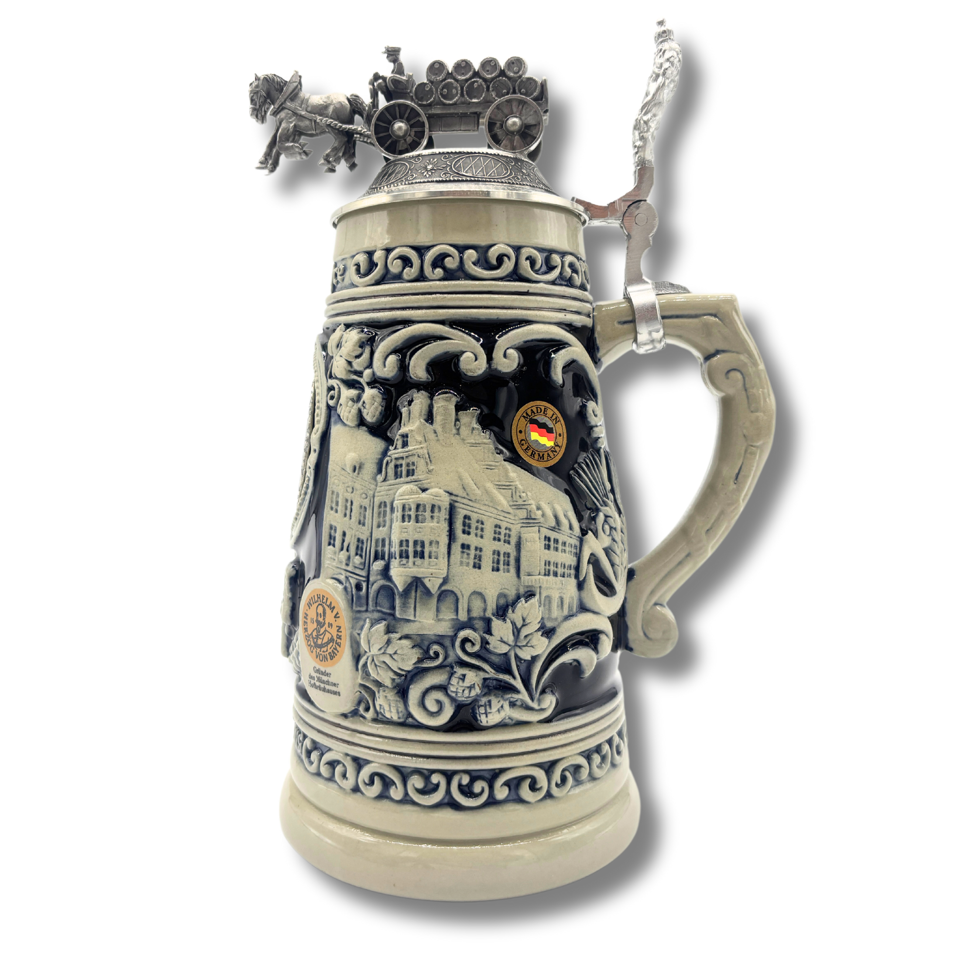 „Reliefbierkrug als Sonderedition mit kunstvoll gestalteten Motiven auf dem Krugkörper, darunter szenische Darstellungen im Schankraum, das Hofbräuhaus aussen und dekorative Muster. Der Zinndeckel ist mit einer detailreichen Skulptur eines Pferdegespanns 